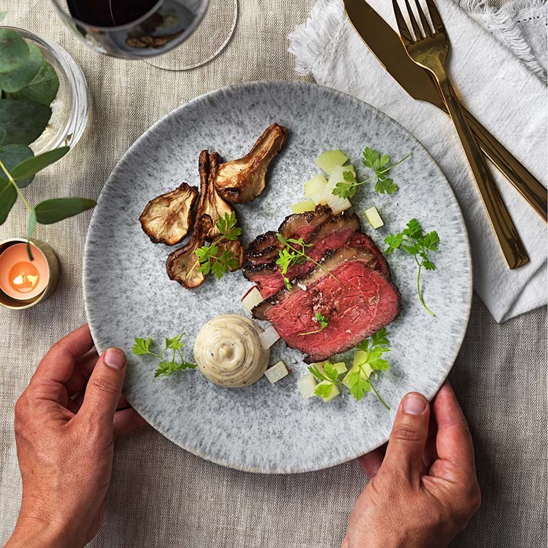 Ljusgrå tallrik med fikonglaserad picanha och diverse tillbehör